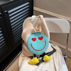 Chic cream knit tote bag with a cute blue plush smiley face and heart eyes charm