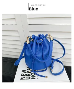 Detail view of blue lychee grain leather bucket bag with gold hardware and drawstring closure
