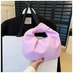 Detail shot of a soft light purple pleated handbag with a stylish knotted top handle