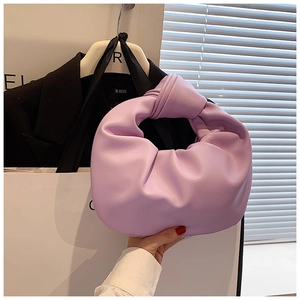 Detail of purple pleated cloud handbag featuring a soft leather texture and knotted handle