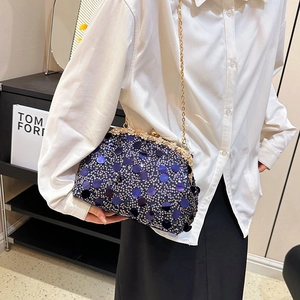 Sac de soirée à paillettes avec fermoir en strass et chaîne dorée porté par un mannequin