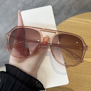 Detail of pink transparent pilot sunglasses with brown gradient lenses and double bridge