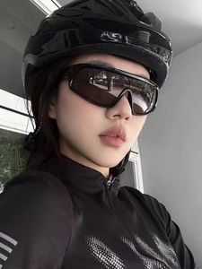 Detail of cycling gear with a black streamlined helmet and oversized sports sunglasses