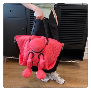Detail of pink quilted tote bag featuring a 3D cartoon doll and durable black straps