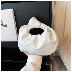 Detail of white pleated cloud bag with knotted handle and soft PU leather texture