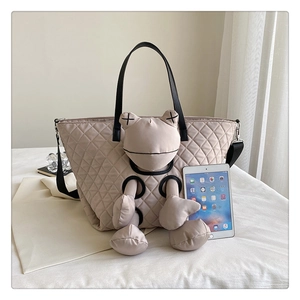 Detail of quilted tote bag featuring a frog mascot with distinctive X embroidered eyes