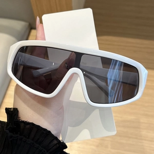 Detail of white oversized frame sunglasses with a modern wrap-around windproof lens design