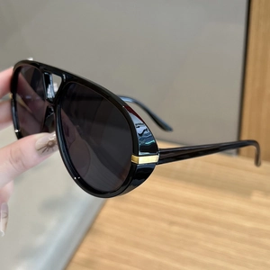 Detail of pilot sunglasses with black frame and decorative gold metal temple hinge