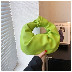 Detail of the lime green cloud bag showing its knotted handle and pleated leather texture