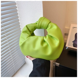 Detail of the iconic knot handle on this bright green pleated cloud bag in soft leather