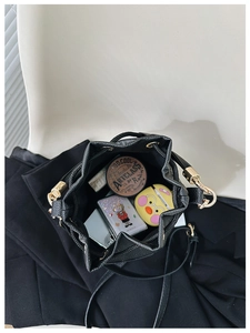 Detailed top view of the black drawstring bucket bag interior showing its large storage capacity