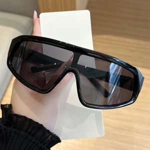 Detailed view of oversized glossy black wrap-around frame with dark grey tinted lenses