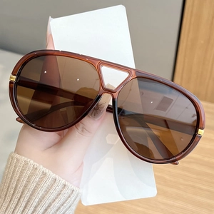 Detail of brown aviator sunglasses with dual-bridge frame and gold metal accents