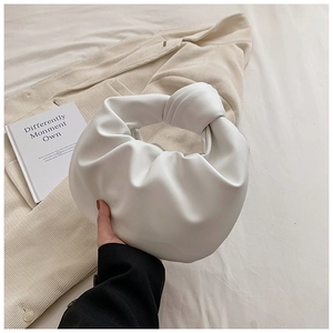 Detail of white knotted handle and soft pleated texture on the cloud handbag