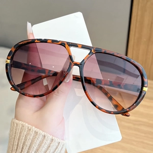 Detail of tortoise shell sunglasses with gradient lenses and gold metal accents