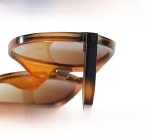Detailed view of firm metal hinges and textured temple of tortoise sunglasses