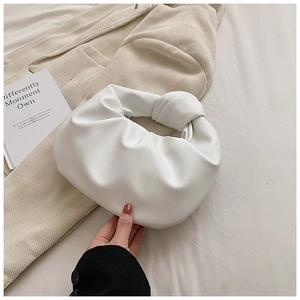 Close-up detail of a white knotted handle and pleated cloud-shaped leather handbag