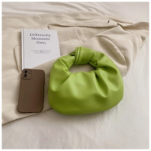 Close-up of fruit green ruched dumpling bag with signature knotted handle and texture