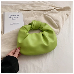 Detail shot of bright green knot handle cloud bag with soft pleated leather texture