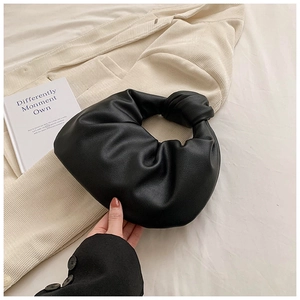 Detail of the signature knotted handle and soft pleats on this black faux leather hobo bag
