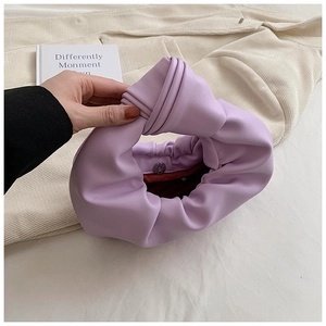 Detail of lavender pleated cloud bag with knotted handle and magnetic closure