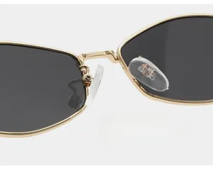 Detail of comfortable clear nose pads on gold metal sunglasses frame with brand logo