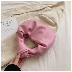 Detail of pink pleated knot handbag with soft PU leather texture and cloud-like design