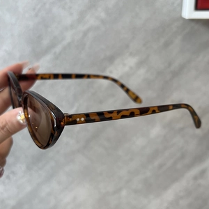 Vue détaillée des lunettes de soleil œil de chat écaillé avec rivets et verres bruns