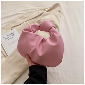 Detail of pink pleated hobo bag with a knotted top handle and fine leather texture