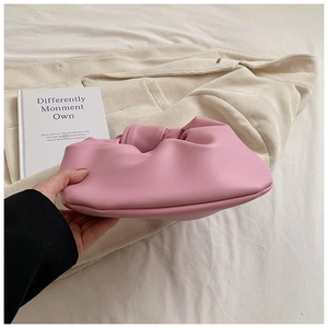 Detail view of pink pleated dumpling bag showing soft texture and side thickness