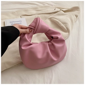 Macro detail of the knot handle and pink pleated leather texture on this trendy cloud bag