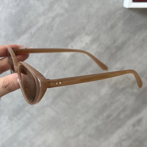 Détail de lunettes de soleil œil-de-chat vintage marron clair avec rivets argentés