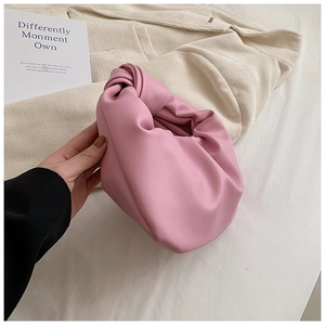 Close-up of pink soft leather handbag with knotted handle and pleated cloud design