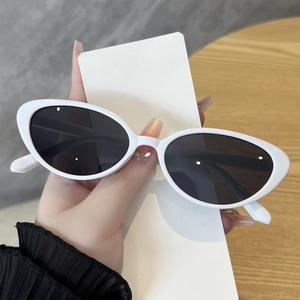 Détail de lunettes de soleil œil-de-chat ovales blanches avec verres polarisés
