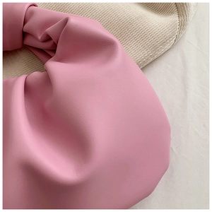 Detailed view of the pink pleated cloud bag featuring soft leather and knotted handle design
