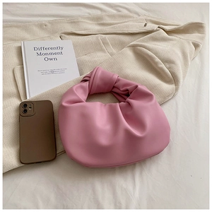 Detail of the pink knot handle hobo bag with soft leather texture on a white background