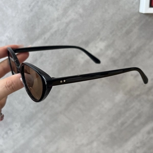 Lunettes de soleil ovales rétro avec monture noire et verres marron à rivets