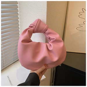 Detail of pink pleated cloud bag with knotted handle and soft leather texture