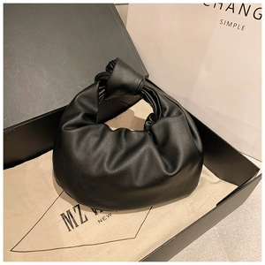 Detail of black pleated cloud handbag with knot handle, dust bag and premium gift box