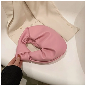 Detail of pink knotted handle and pleated cloud bag texture in soft PU leather