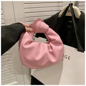 Detail of pink knotted handle and pleated cloud bag texture in smooth faux leather