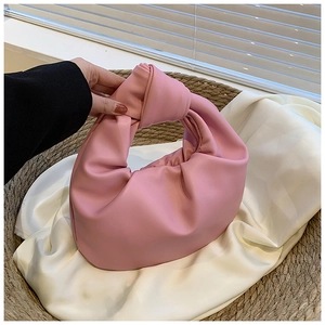 Detail of pink knotted handle and pleated leather texture on a soft cloud hobo bag