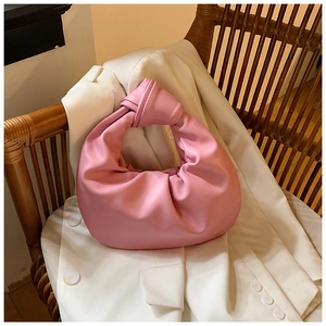 Detailed view of pink knotted handle on pleated crescent cloud bag with leather texture