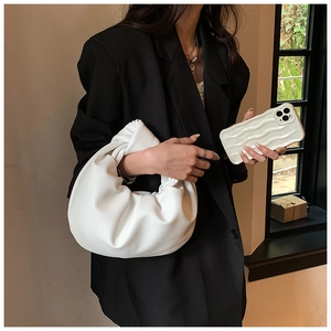 Detail of soft white pleated cloud handbag with knotted handle and matching phone case