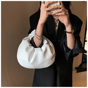 Detail of soft white pleated crescent handbag with premium leather texture for women