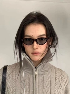 Detail of vintage burgundy oval sunglasses with three-point metal rivets on model