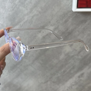 Detail view of transparent round cat-eye frames with anti-blue light coating and metal studs