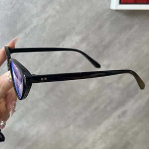 Detail of vintage cat-eye glasses frame with blue light lenses and metal rivet accents