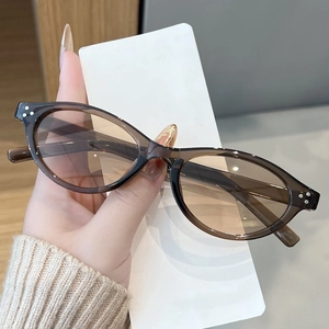 Detail of amber tortoiseshell sunglasses with three silver metal rivets on the frame corner
