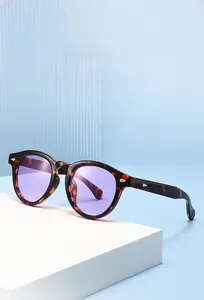 Detail of vintage round sunglasses featuring tortoiseshell frames and purple resin lenses